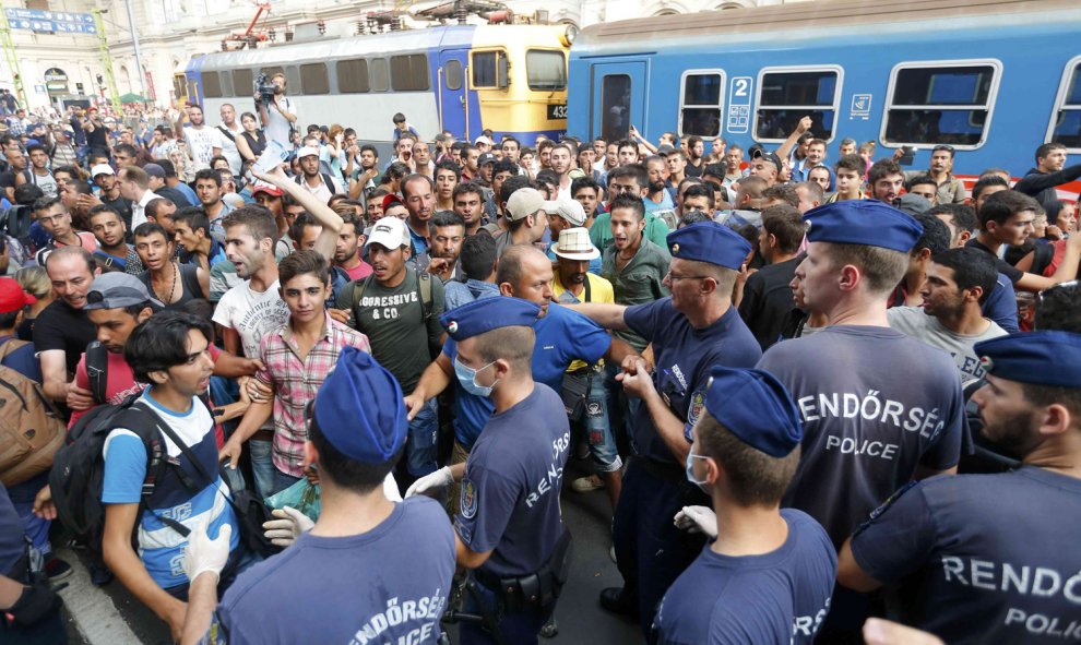 Cientos de refugiados protestan ante la policía, que les impide acceder a los trenes para viajar a otros países de Europa. REUTERS