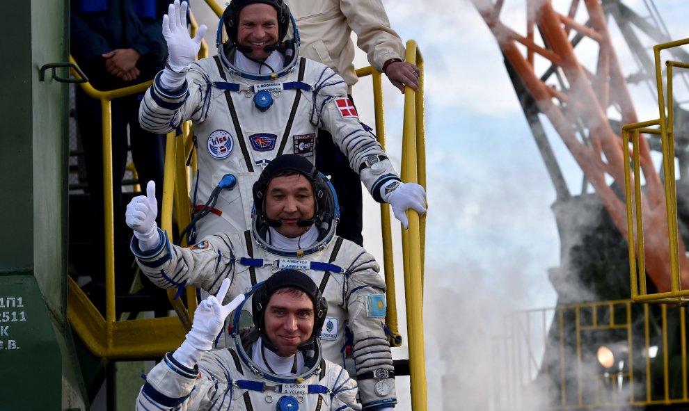 Cosmonauta de Kazajstán Aydyn Aimbetov, el ruso Sergei Volkov y el de Dinamarca Andreas Mogensen saludan desde la Agencia Espacial Europea al subir a bordo de la nave espacial Soyuz TMA- 18M en el cosmódromo de Baikonur, Rusia, 2 de septiembre de 2015. RE