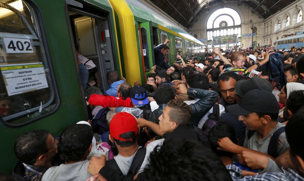 Decenas de refugiados intentan subirse a un vagón de tren entre empujones tras la autorización del Gobierno húngaro. /REUTERS