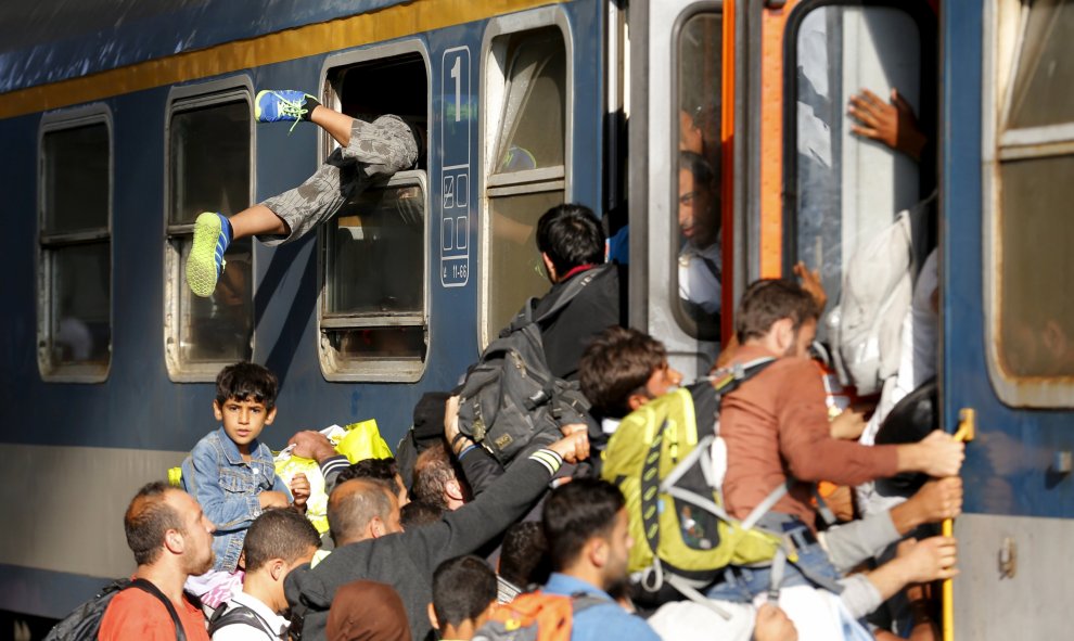Los refugiados han intentado acceder a los trenes de todas las maneras posibles. /REUTERS