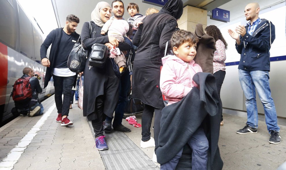 Refugiados caminan por la estación de trenes de Viena, recibidos entre aplausos. /REUTERS
