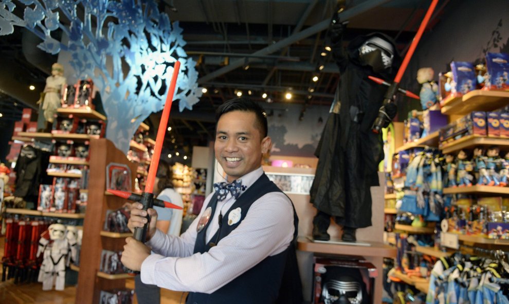 Jake gerente de una tienda Disney en California (EEUU), muestra la nueva espada láser de la película 'Star Wars, el despertar de la fuerza'. EFE/EPA/MIKE NELSON