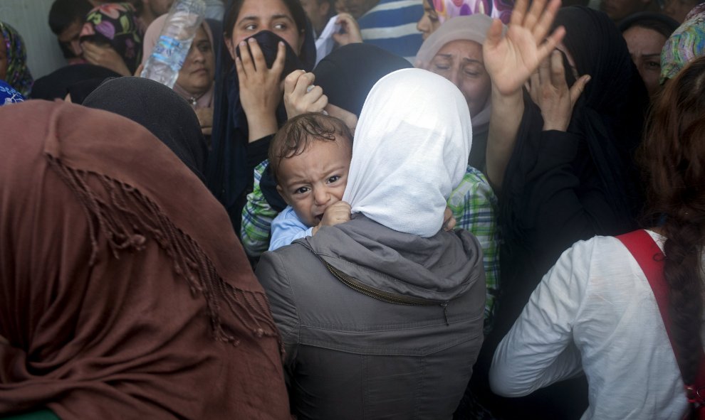Un bebé llora durante enfrentamientos entre los refugiados afganos y sirios por la prioridad que se está dando a estos últimos en el proceso de registro en el puerto de Mitilene, en la isla griega de Lesbos, 6 de septiembre de 2015. REUTERS / Dimitris Mic