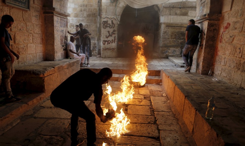 Un manifestante palestino da una patada a un neumático en llamas durante los enfrentamientos entre palestinos y policías israelíes en la Ciudad Vieja de Jerusalén, 15 de septiembre de 2015. REUTERS/Ammar Awad