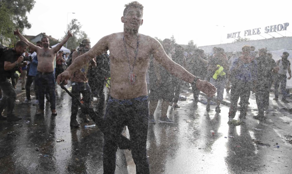 Migrantes protestan frente a los antidisturbios húngaros, que les han intentado disuadir con gas lacrimógeno y cañones de agua, cerca de Röszke. REUTERS