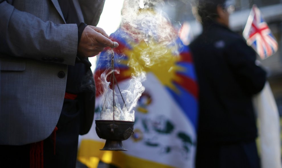 Un religioso quema incienso delante del líder espiritual tibetano, el Dalai Lama, en Cambridge. REUTERS