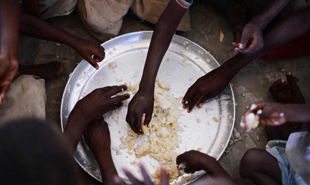Niños desplazados comen arroz de un plato compartido en Kenya. CARL DE SOUZA (AFP)