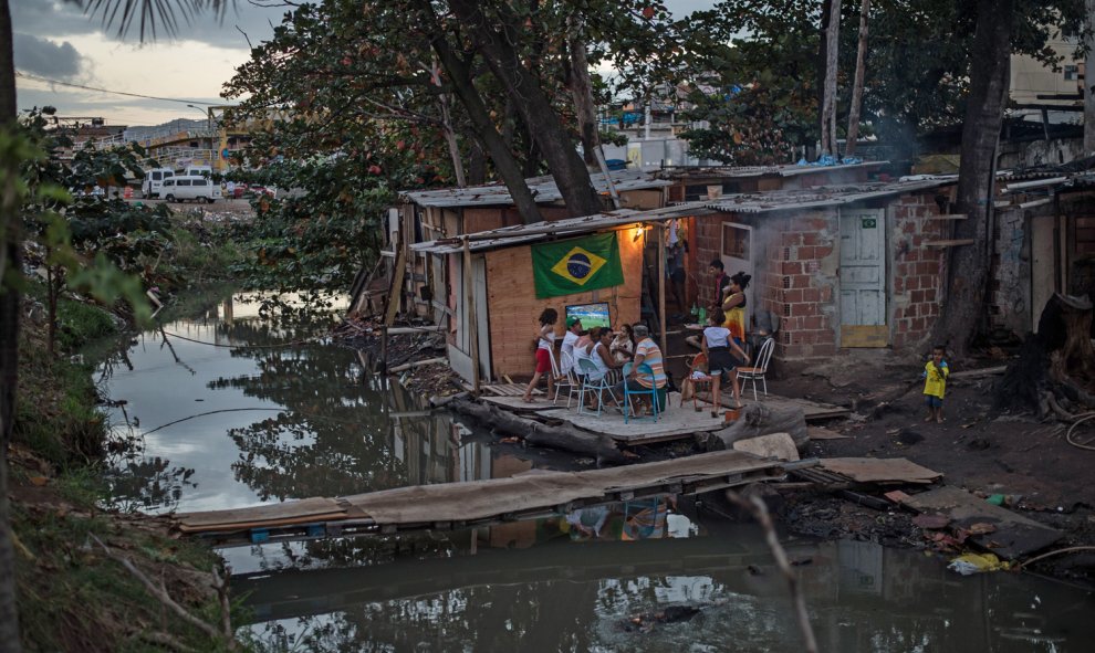 Una familia de la favela de Mare, en Río de Janeiro, ve el partido de fútbol de la selección de Brasil durante el Mundial de 2014. YASUYOSHI CHIBA (AFP)