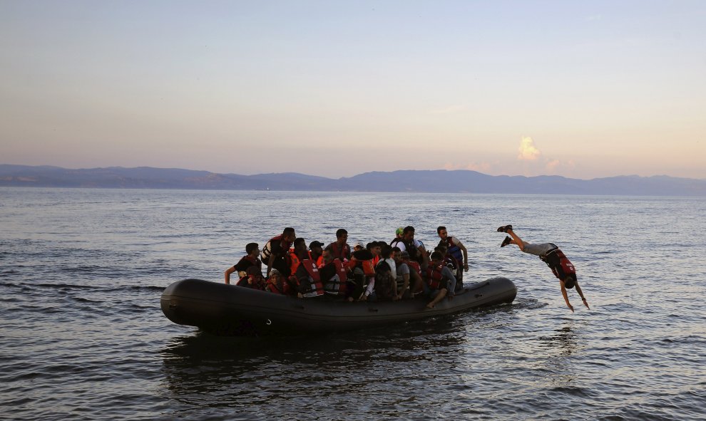 Refugiado sirio se tira al mar cuando su embarcación se acerca a una playa de la isla griega de Lesbos, después de cruzar el Mar Egeo. REUTERS