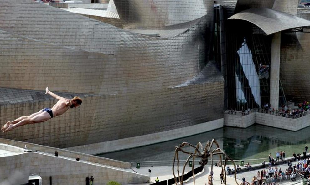 El clavadista estadounidense Andy Jones durante la ronda clasificatoria para la final de la prueba del 'Red Bull Cliff Diving 2015' de Bilbao, ante el Museo Guggenheim de la capital vizcaína. EFE/LUIS TEJIDO