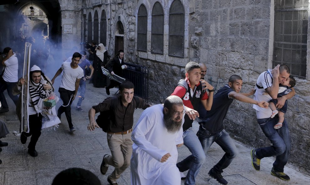 Manifestantes palestinos huyen mientras la policía israelí lanza una granada aturdidora en la Ciudad Vieja de Jerusalén, 28 de septiembre de 2015. REUTERS / Ammar Awad