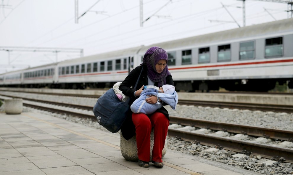 Una emigrante da el biberón a su hijo antes de subirse abordo de un tren en la estación de Tovarnik en Croacia, 28 de septiembre de 2015. REUTERS/Antonio Bronic