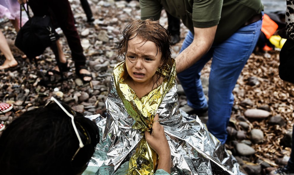 Una niña siria llora al llegar a la orilla de la isla griega de Lesbos después de cruzar el Mar Egeo de Turquía el 28 de septiembre de 2015. AFP PHOTO / ARIS MESSINIS