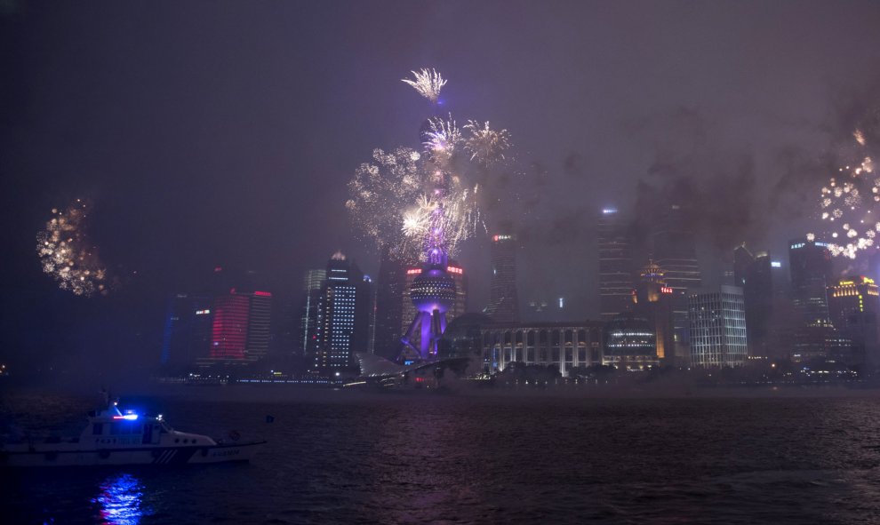 Fuegos artificiales iluminan el cielo del distrito financiero de Lujiazui en Shanghái durante las fuertes lluvias de otoño, el 28 de septiembre de 2015. AFP PHOTO / JOHANNES EISELE