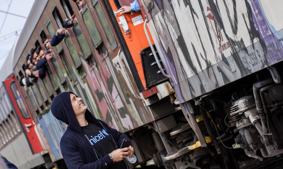 El embajador de buena voluntad de Unicef y actor Orlando Bloom sonríe a los refugiados que aguardan a bordo de un tren con destino a la frontera serbia, en Gevgelija (Macedonia). EFE/Georgi Licovski