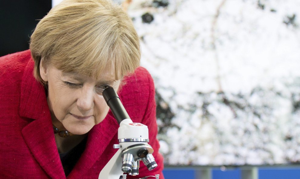 La canciller alemana Angela Merkel observa a través de un microscopio en la Cancillería alemana en Berlín (Alemania) hoy, 30 de septiembre de 2015. Merkel invitó a los ganadores del concurso de ciencias "La Juventud en la Ciencia". EFE/Kay Nietfeld