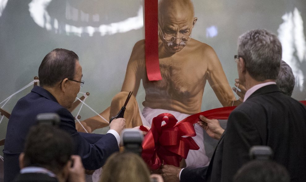 El Secretario General de la ONU, Ban Ki -moon, corta la cinta de una pintura de Mahatma Gandhi durante un evento de la Asamblea General de las Naciones Unidas, con motivo del Día Internacional de la No Violencia. REUTERS