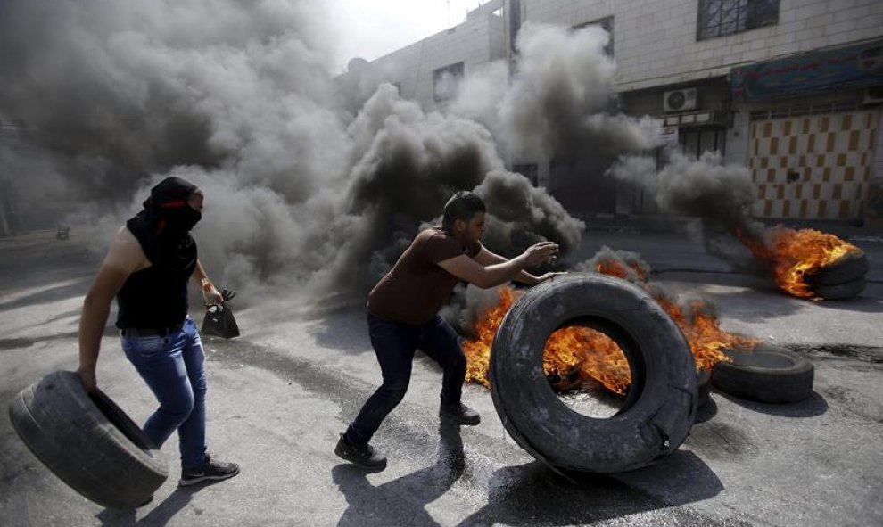 Manifestantes palestinos se enfrentan a agentes de policía israelíes en Hebrón, Cisjordania. EFE/Abed Al Hashlamoun