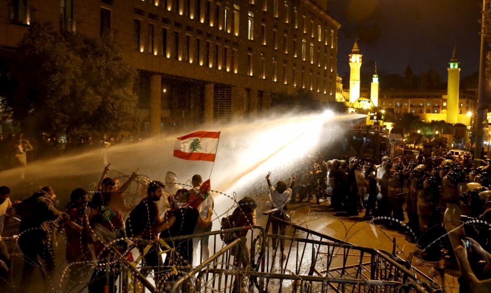 Manifestantes libaneses se rocían con agua durante una protesta contra la corrupción y contra la incapacidad del gobierno para resolver una crisis de eliminación de basura , en la plaza Mártir, Downtown Beirut , Líbano. REUTERS