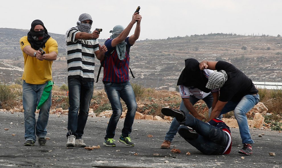 Miembros infiltrados de las fuerzas de seguridad israelíes golpean y detienen a un palestino que lanzaba piedras durante los enfrentamientos en Beit El, a las afueras de la ciudad cisjordana de Ramala.- ABBAS MOMANI (AFP)