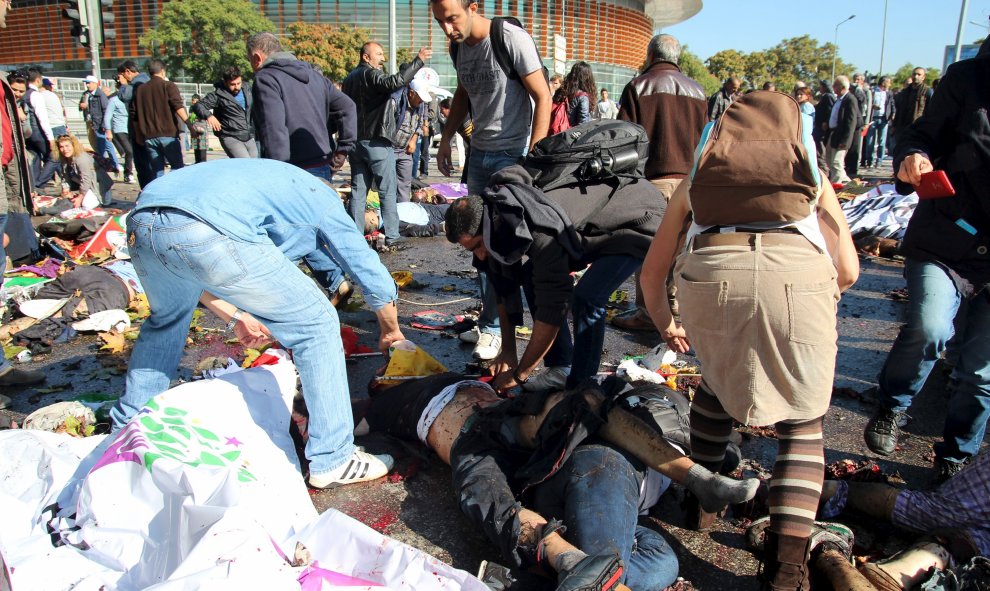 Varias personas tratan de ayudar a los heridos por los atentados en el centro de Ankara durante una marcha pro-kurda. REUTERS/Tumay Berkin