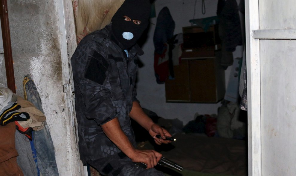 Un oficial de una unidad anti-inmigrantes ilegales de Libia lleva a cabo una redada de madrugada en un escondite de inmigrantes en Trípoli, Libia, 13 de octubre de 2015. REUTERS / Hani Amara