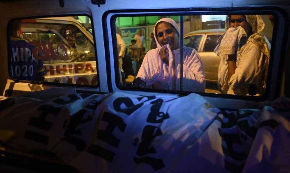 Mujeres paquistaníes lloran junto al cuerpo de su familiar que murió en un deslizamiento de tierra en Karachi, el 13 de octubre de 2015. Trece personas, entre ellas siete niños murieron aplastados cuando un deslizamiento de tierra golpeó sus chozas mientr