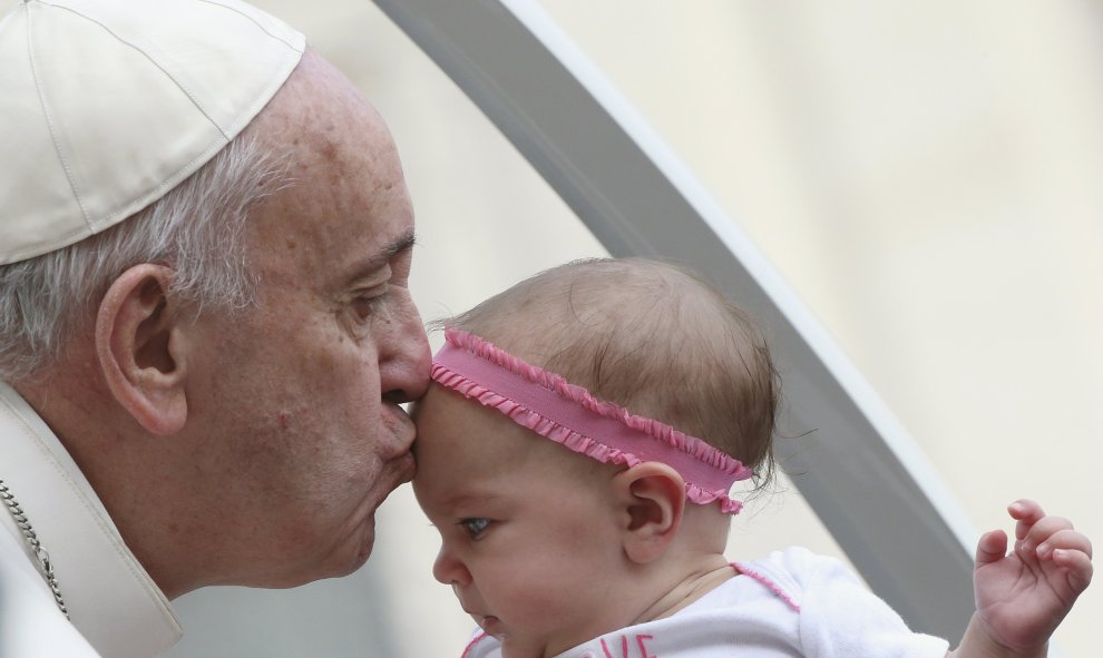 El Papa Francisco besa a un bebé a su llegada a la plaza de San Pedro en el Vaticano, 14 de octubre de 2015. REUTERS / Stefano Rellandini