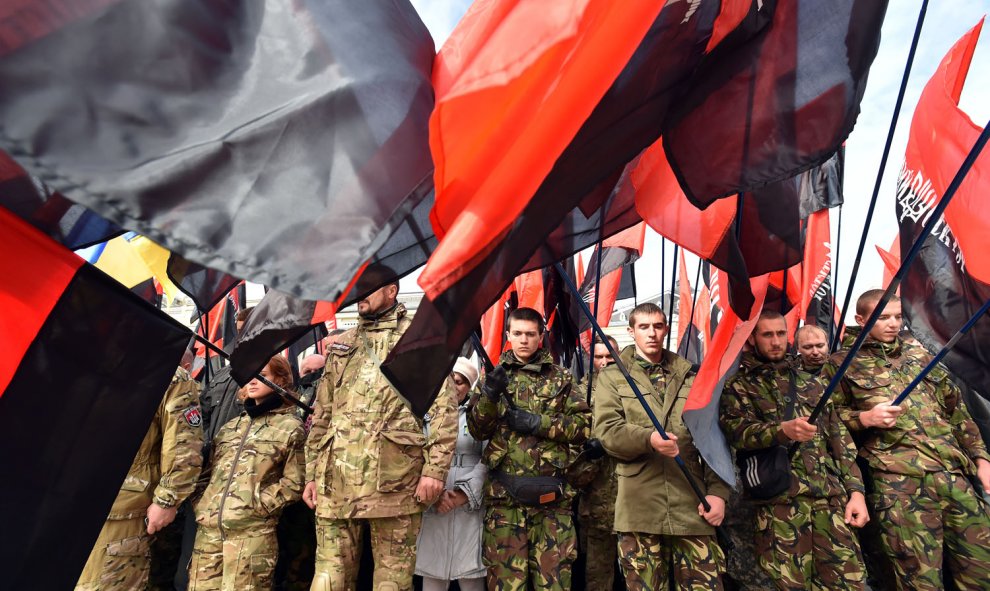 Los miembros del movimiento de extrema derecha Right Sector y simpatizantes de partidos nacionalistas ondean banderas mientras asisten a un mitin en Kiev el 14 de octubre de 2015, para conmemorar el Día para Defender Ucrania y pedir la independencia de Po