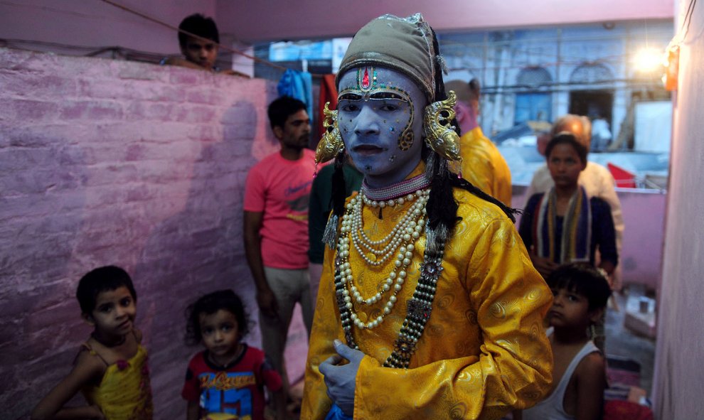 Un artista indio vestido como el dios hindú Rama, se coloca debajo de un ventilador para secar su maquillaje antes de una procesión religiosa que se celebra en el festival de Dussehra en Allahabad, el 14 de octubre de 2015. AFP/SANJAY Kanojia