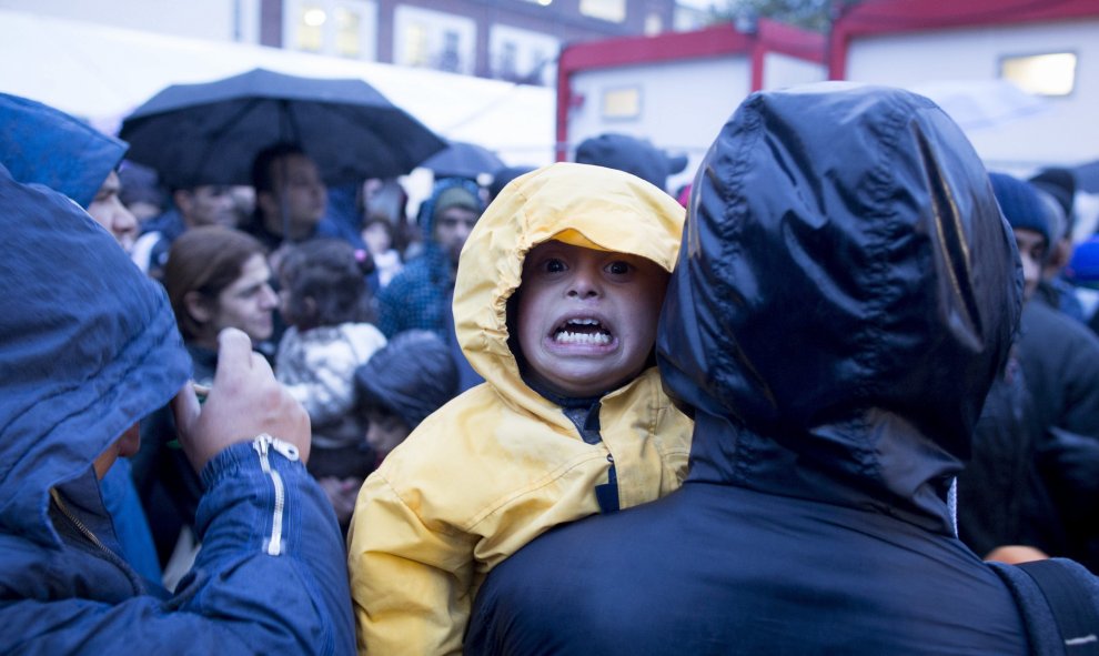 Un niño llora mientras cientos de refugiados esperan con frío a las puertas de la Oficina de Sanidad y Asuntos Sociales en Berlín. EFE/Kay Nietfeld