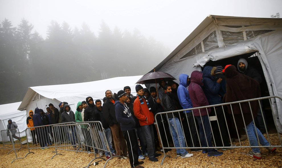 Varios refugiados hacen cla para comer en el refugio temporal de Schwarzenborn (Alemania). REUTERS/Kai Pfaffenbach