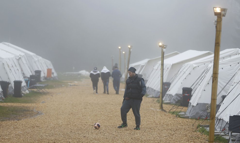 Un refugiado juega al fútbol para combatir las bajas temperaturas en el refugio temporal de Schwarzenborn (Alemania). REUTERS/Kai Pfaffenbach