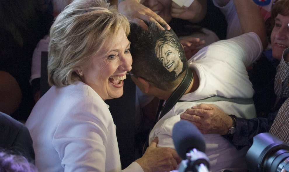 Hillary Clinton, la candidata demócrata a la presidencia de Estados Unidos, posa para una foto con una seguidora, que se ha rapado la cabeza con la imagen de la política, en un mitin en San Antonio, Texas. REUTERS/Darren Abate