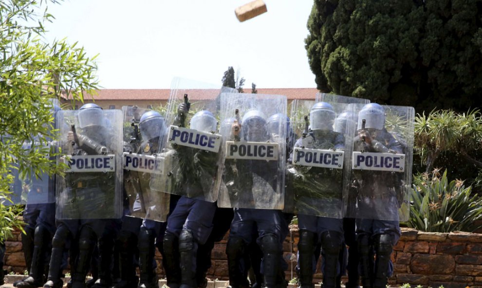 Antdisturbios son atacados con ladrillos durante una protesta de estudiantes en Pretoria (Sudáfrica). REUTERS/Sydney Seshibedi