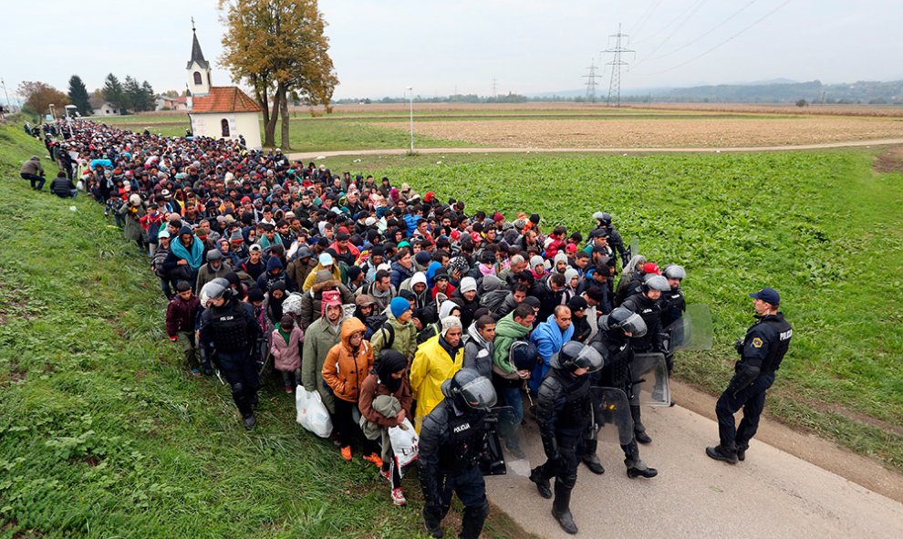 Un millar de inmigrantes son escoltados por policías eslovenos desde el cruce de la frontera con Croacia.- AFP