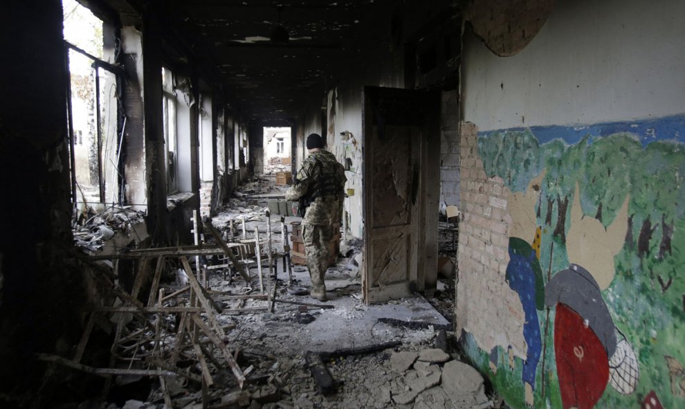 Un soldado ucraniano camina en una escuela destruida en el pueblo de Pisky cerca de Donetsk . AFP/ Anatolii STEPANOV