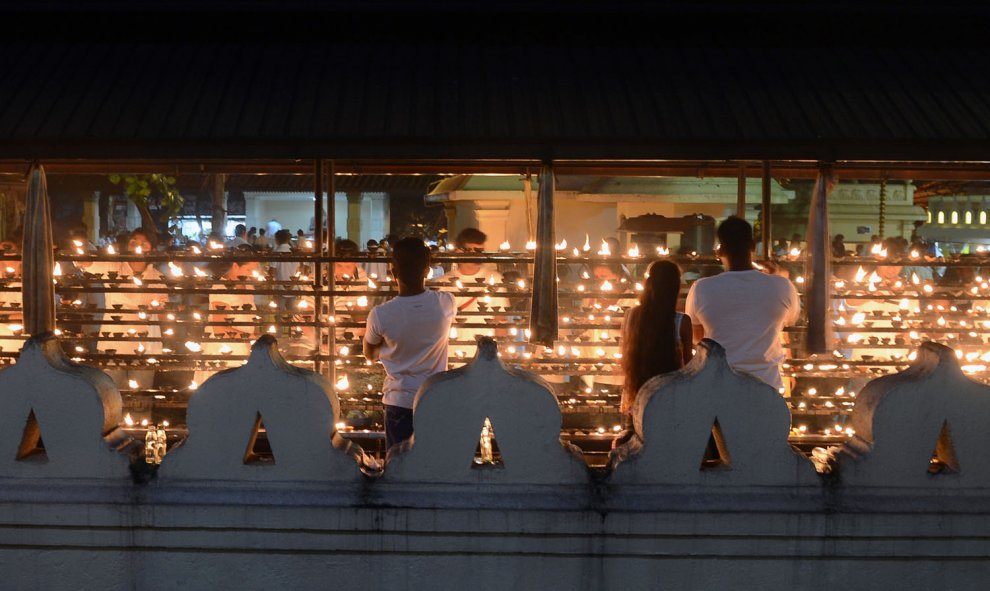 Devotos budistas de Sri Lanka rezan durante Poya, un día religioso de la luna llena en un templo en Colombo, el 27 de octubre de 2015. La nación de la isla predominantemente budista marca cada luna llena como una fiesta religiosa clave. AFP/LAKRUWAN WANNI