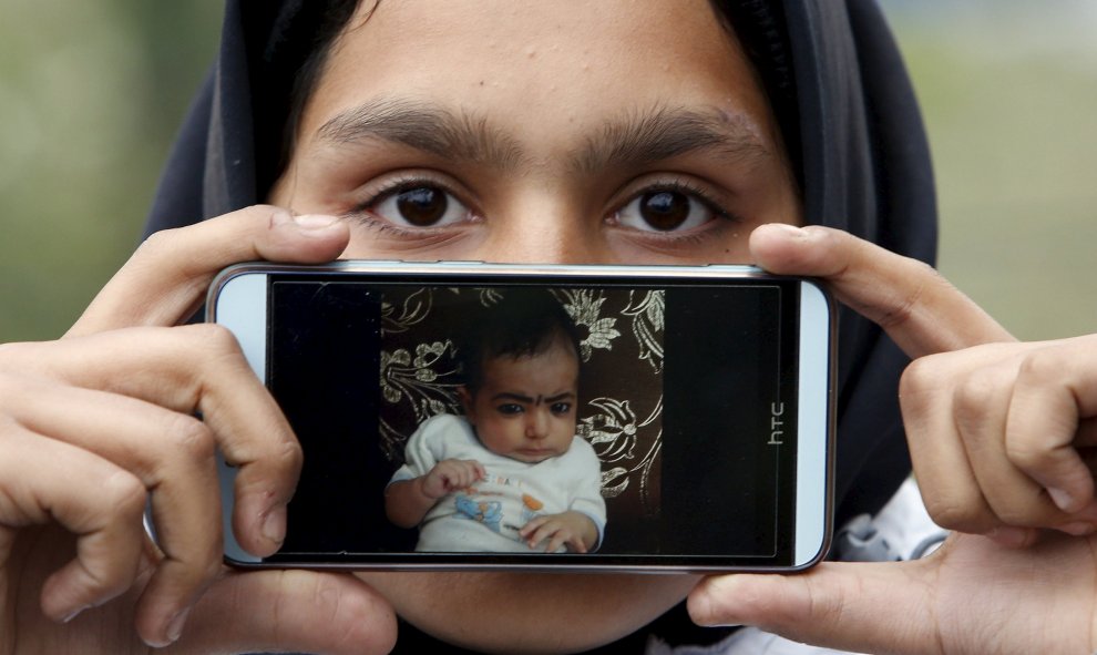 Rubina, llegada a Europa desde Kabul, Afganistán, muestra una foto de su sobrino Iman mientras espera para cruzar la frontera entre Eslovenia y Austria en Sentilj, Eslovenia.- REUTERS / Srdjan Zivulovic