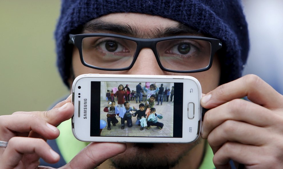 Basas es un refugiado sirio, natural de Damasco, la capital Siria. En la imagen de su teléfono, muestra a los niños de la escuela en la que trabajaba como voluntario. Ahora espera para cruzar la frontera entre Eslovenia y Austria en Sentilj.- REUTERS / Sr