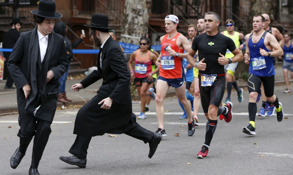 Judíos ortodoxos tratan de cruzar una calle en Williamsburg antes que lleguen los corredores del maratón de Nueva York. REUTERS/Shannon Stapleton