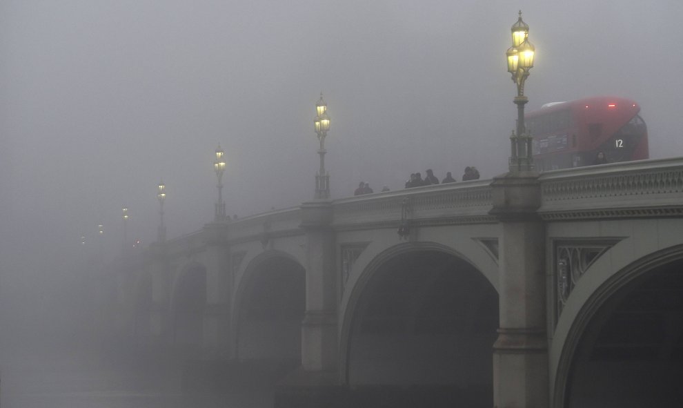 Trabajadores cruzan el puente de Westminster en una mañana brumosa en Londres.- REUTERS