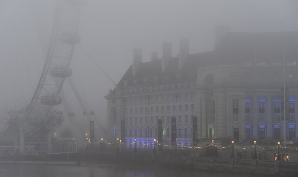 La noria de London Eye y el edificio County Hall al lado del río Támesis, en una mañana de niebla en Londres.- REUTERS