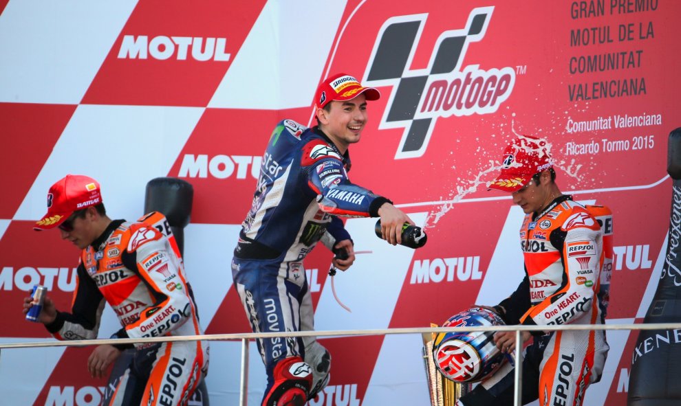 Jorge Lorenzo (Yamaha) celebra en el podio su triunfo en en mundial de MotoGP, entre Marc Marquez y Dani Pedrosa. REUTERS/Heino Kalis