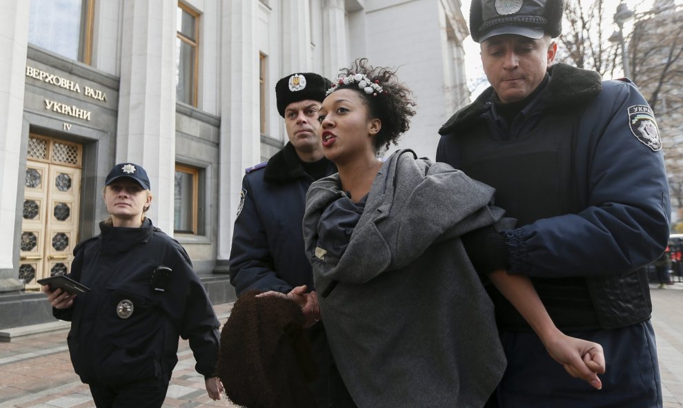 Policías ucranianos arrestan a una activista del movimiento Femen durante una protesta contra la homofobia delante del Parlamento en Kiev (Ucrania), en la que han reclamando que se corrija el Códido Laboral del país para asegurar la armonización de la leg