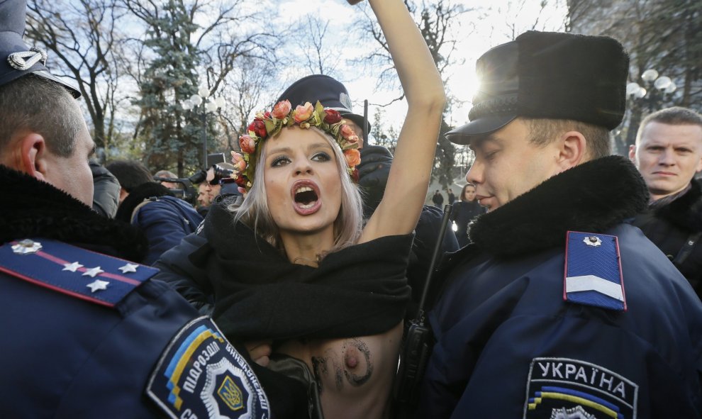 Un policía ucraniano arresta a una activista del movimiento Femen durante una protesta contra la homofobia delante del Parlamento en Kiev (Ucrania). EFE/Sergey Dolzhenko