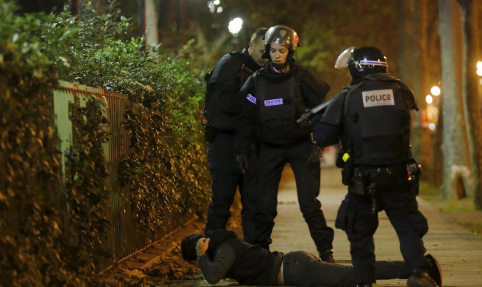 Un hombre permanece tumbado en el suelo mientras policías franceses comprueban su identidad. REUTERS
