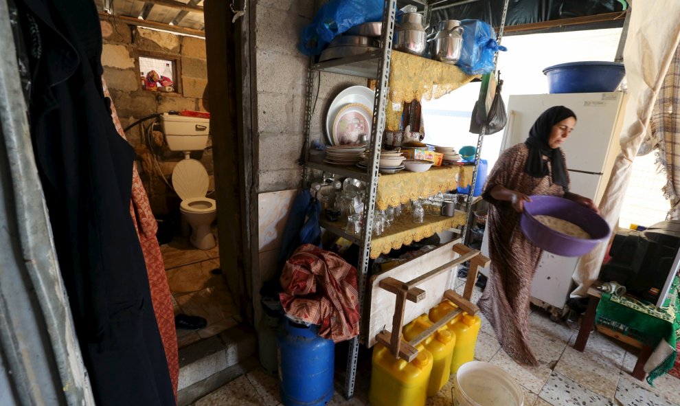 Una mujer pasa cerca de la entrada de un inodoro en un refugio improvisado utilizado por una familia palestina en Khan Younis, en el sur de la Franja de Gaza. REUTERS / Ibraheem Abu Mustafa