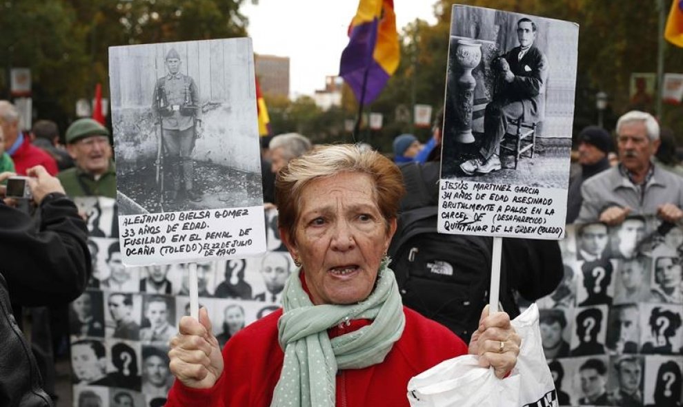 Una mujer con dos pancartas en la marcha estatal por la Memoria Histórica. EFE/Paco Campos
