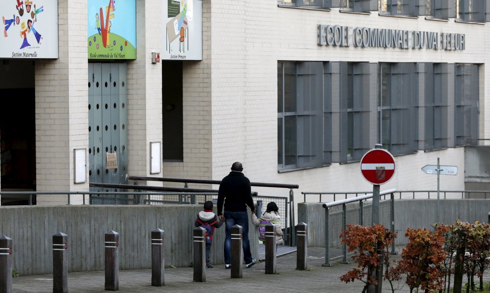 Un hombre vuelve a casa con sus hijos tras descubrir que la escuela estaba cerrada por el riesgo de atentados que hay en la capital belga.- REUTERS.